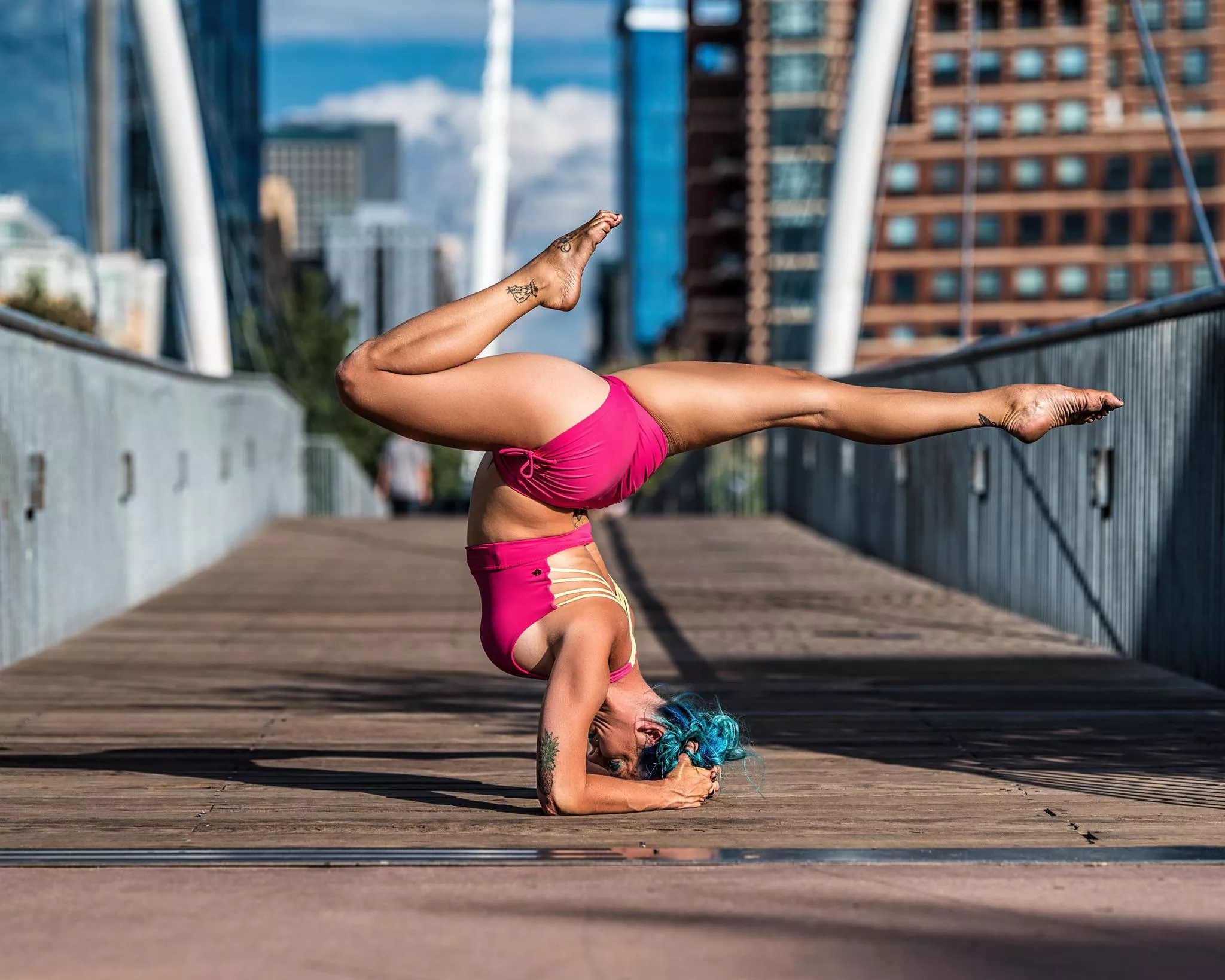 Cherise pretty in pink and blue hair doing a pincha/forearm balance looking to sting like a scorpion. posted by YogaPhotographer