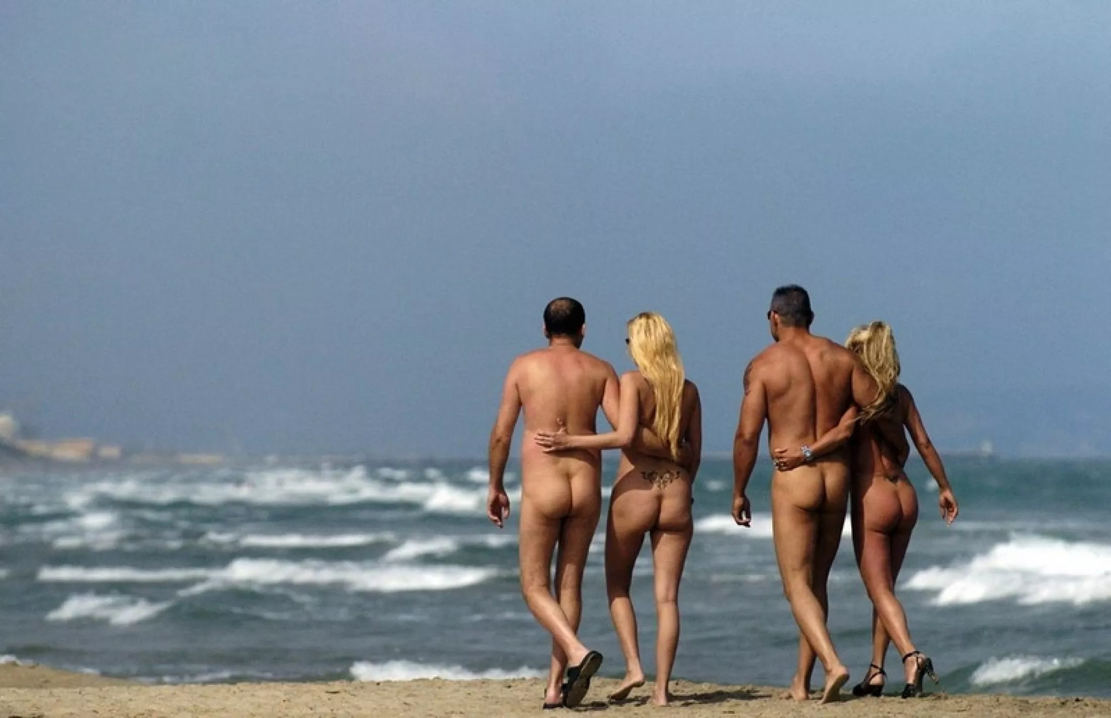 Lady on the right, must be annoying walking in the sand in heels. posted by NaturistPictures