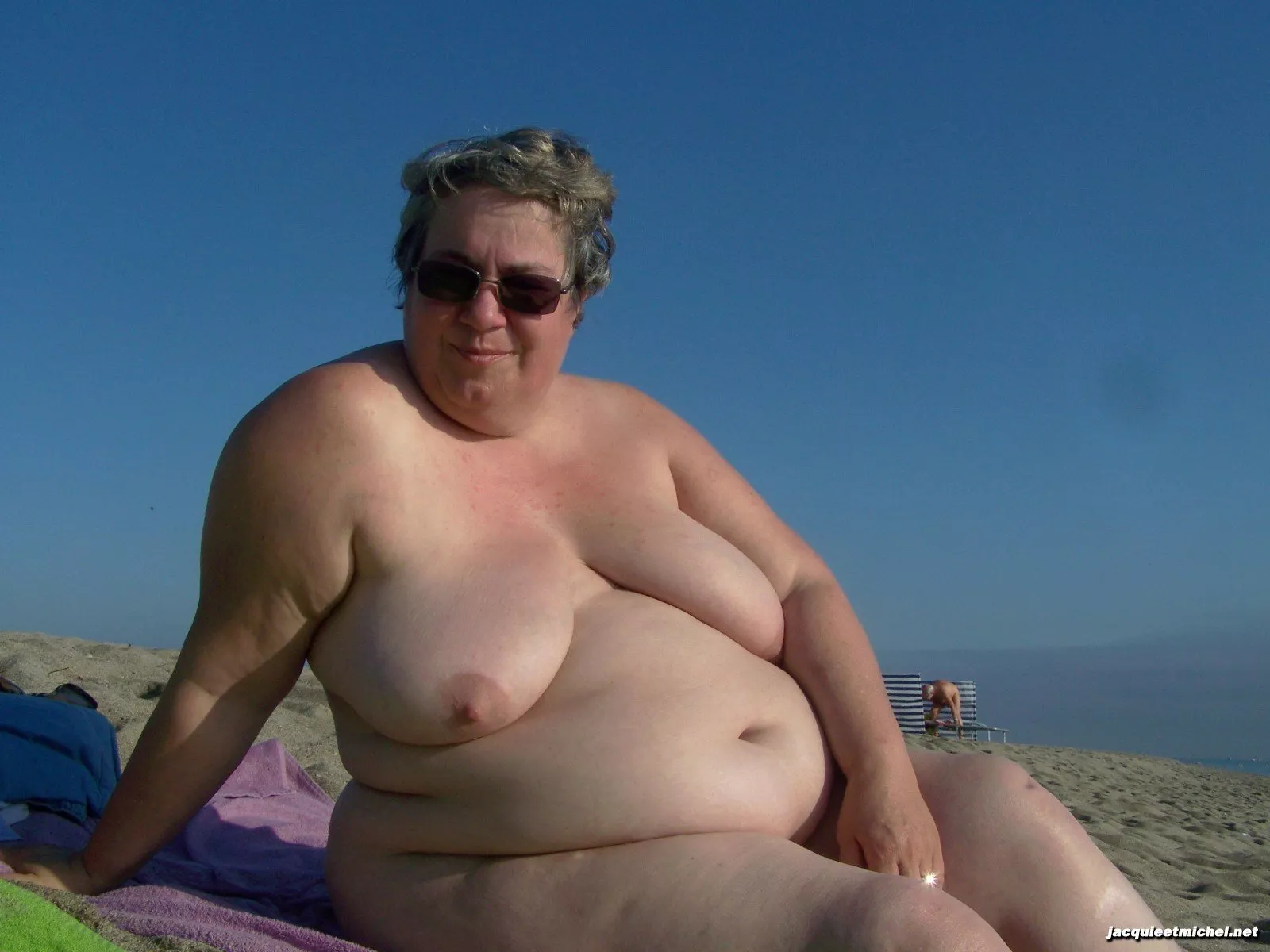 Older nudist with a big belly sitting on the beach posted by Udderluvr2020