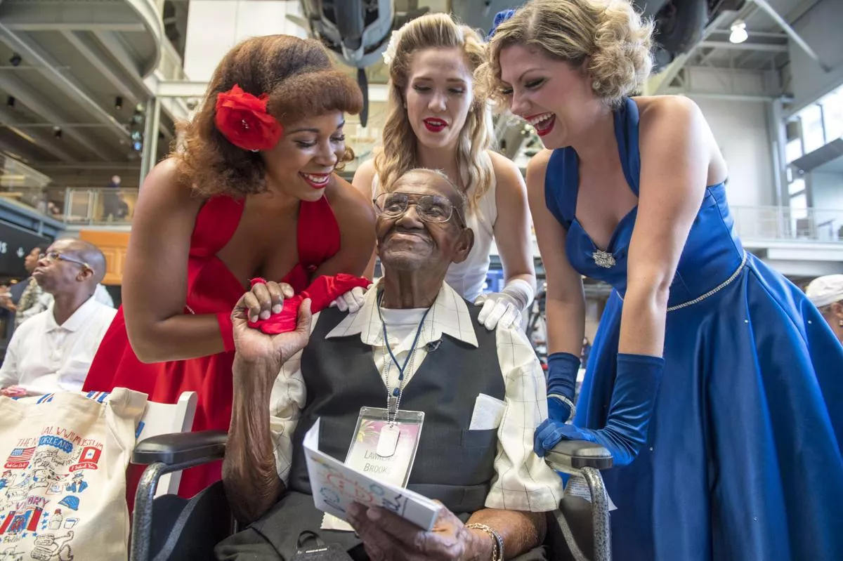 Victory Belles give World War II veteran Lawrence Brooks a birthday card and kiss for his 110th birthday celebration at the National WWII Museum posted by cubicleninja